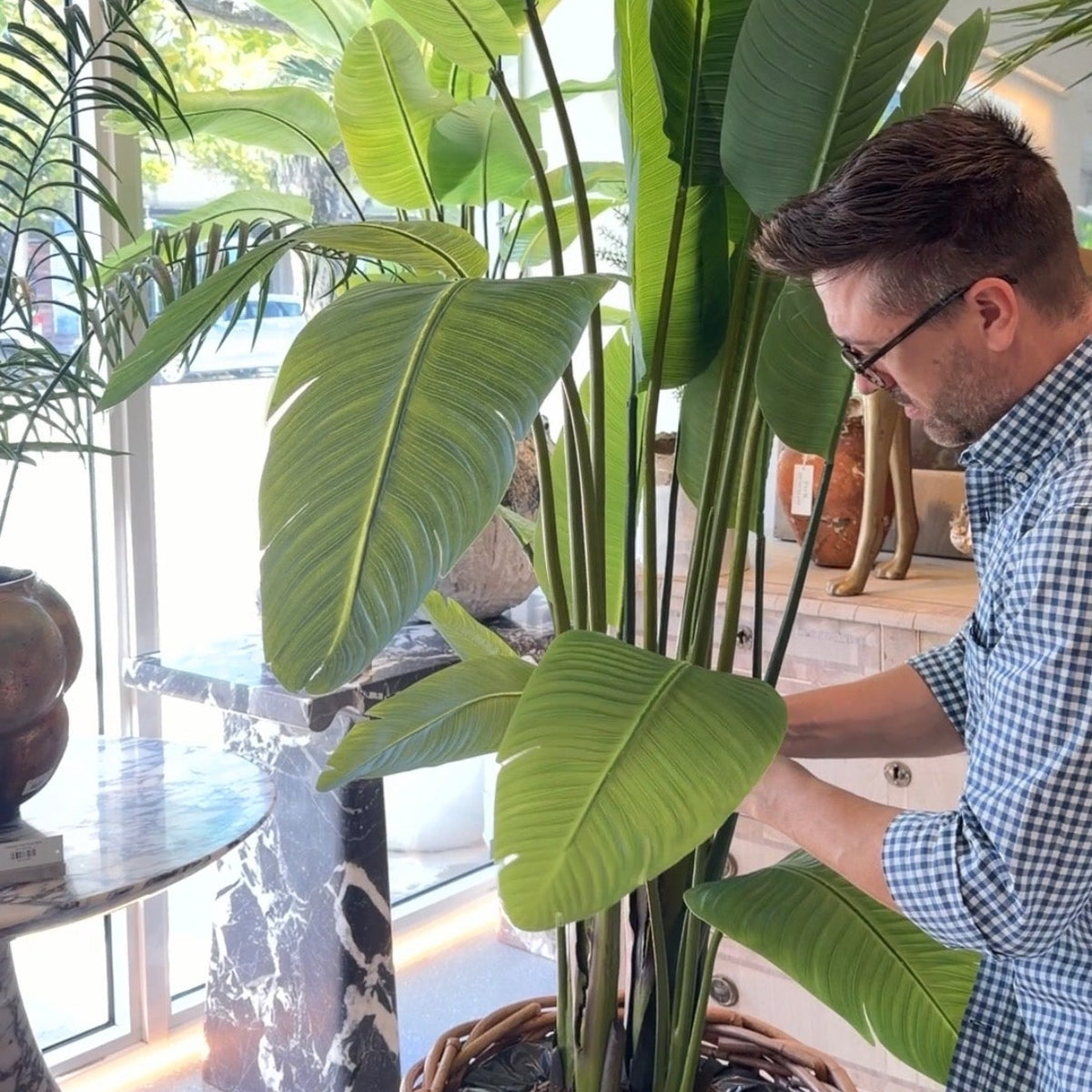 Ryan Lewis Creative Director of Palm Bungalow shaping the leaves of a faux travellers palm by hand.