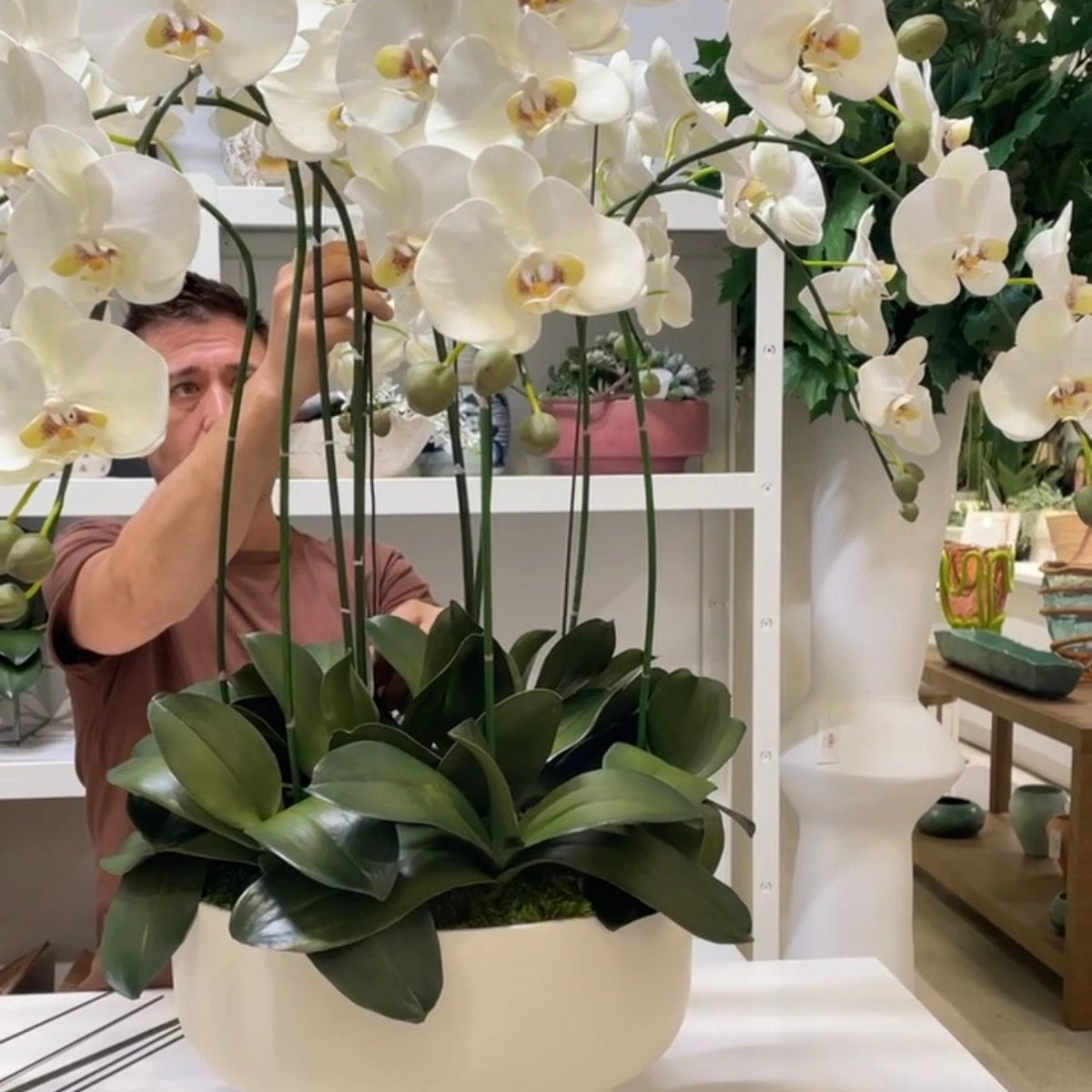 Creative Director Ryan hand shaping a faux orchid centerpiece at Palm Bungalow in west palm beach.
