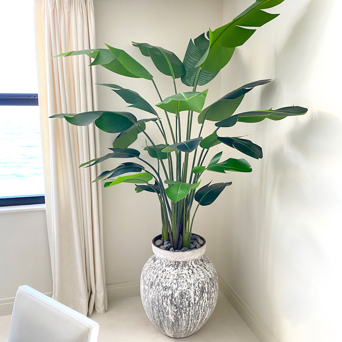 a faux 7' travellers palm tree in a rustic planter by Palm Bungalow