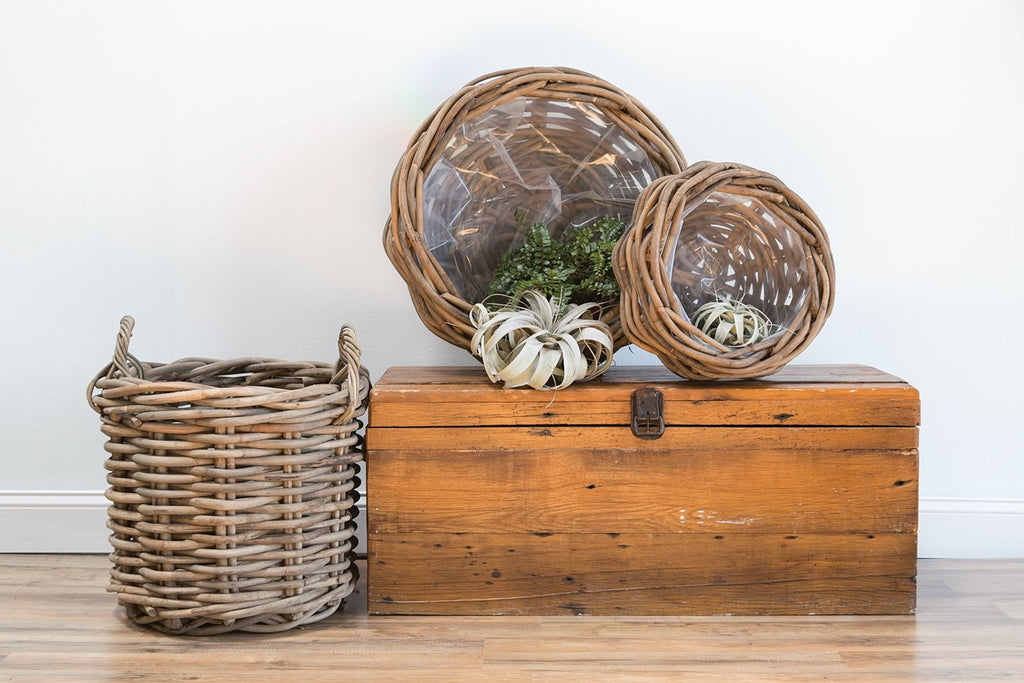 Bungalow woven bowls displayed on a wood chest beside a woven basket